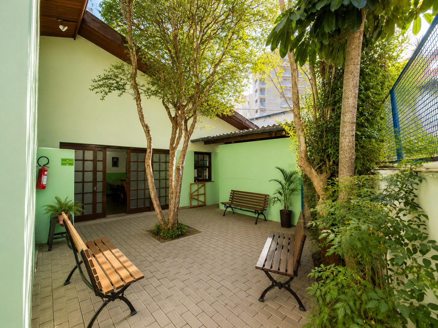 Área externa arborizada com bancos — Casa de Repouso Anália Franco
